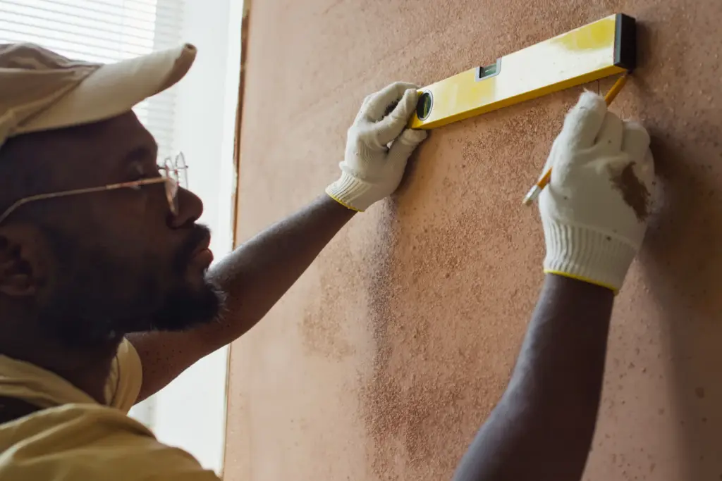 man-measures-wall-for-renovation-at-home-HESXE54