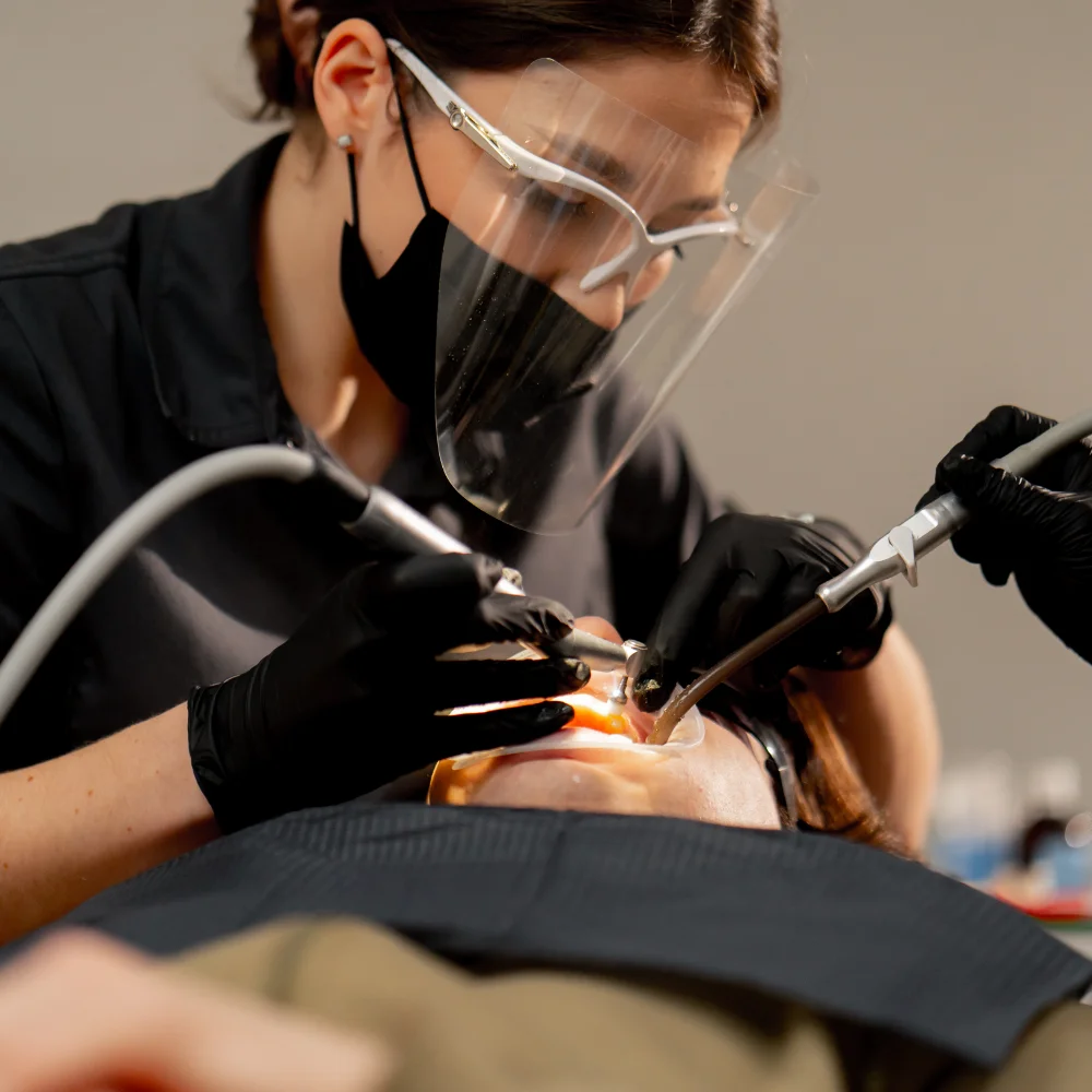 dental-office-girl-dentist-doing-cleaning-to-young-PH3CV7V