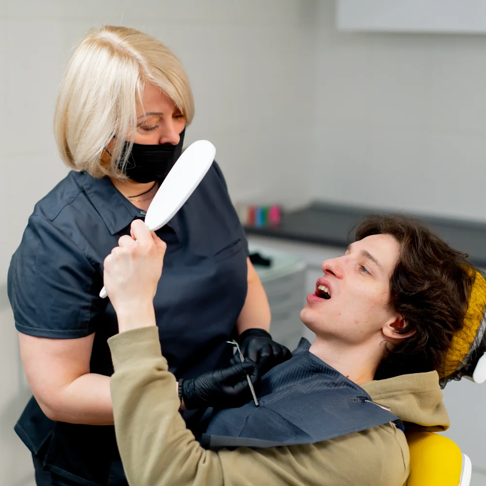 young-man-examined-by-a-caring-dentist-7GUBFME