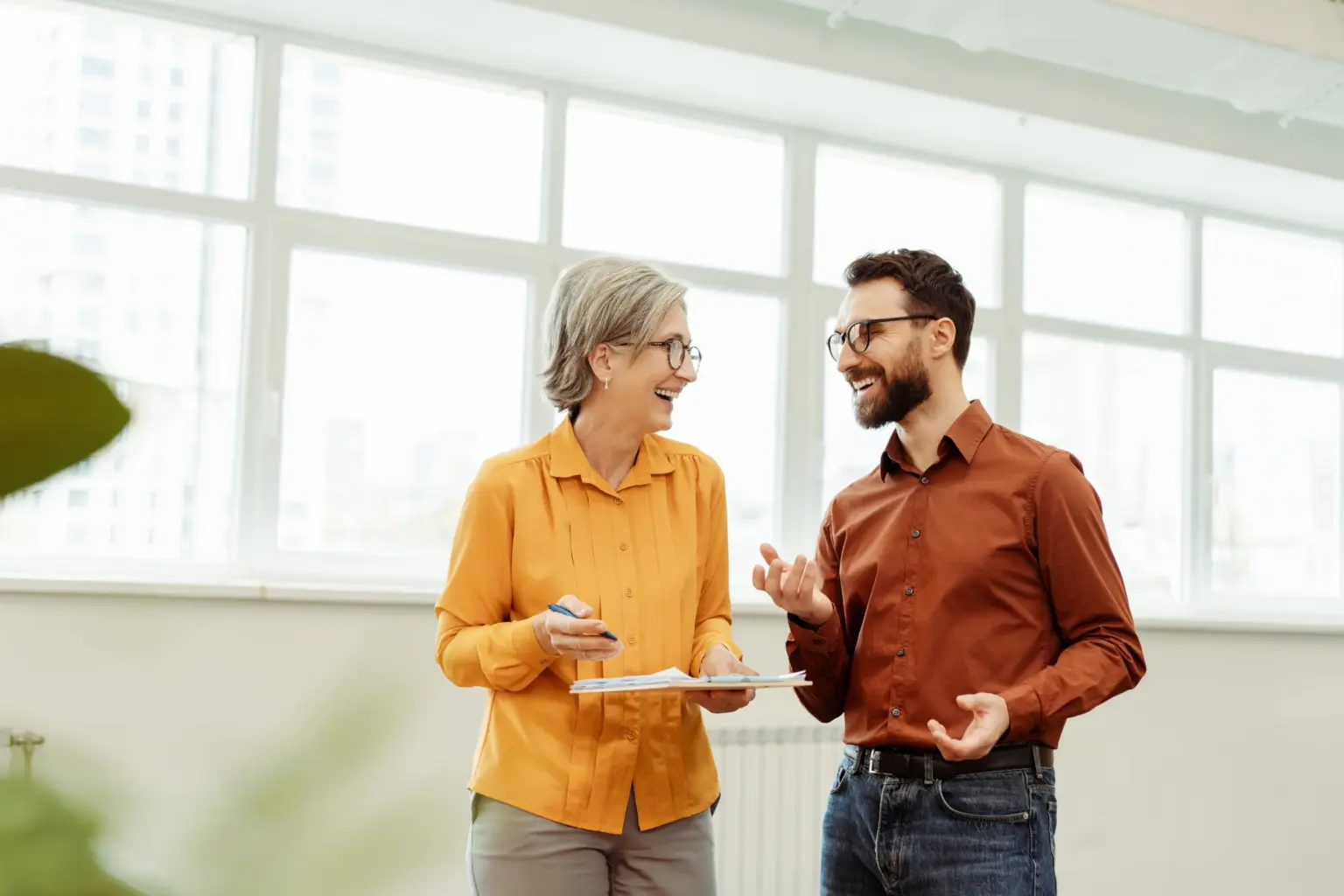 smiling-colleagues-discussing-work-in-a-bright-off-JBV5B5B
